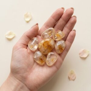 Natural citrine tumble stone polished yellow crystal shown in front side top and angled views