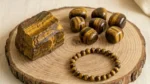 Tiger Eye Raw Stone featuring a natural unpolished crystal with golden-brown bands and a rich earthy texture.