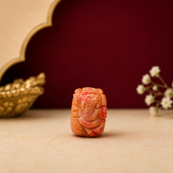 Natural Red Coral Ganesh Idol (Moonga Ganesh) handcrafted from certified natural red coral with premium maroon and cream background by Shraddha Shree Gems.