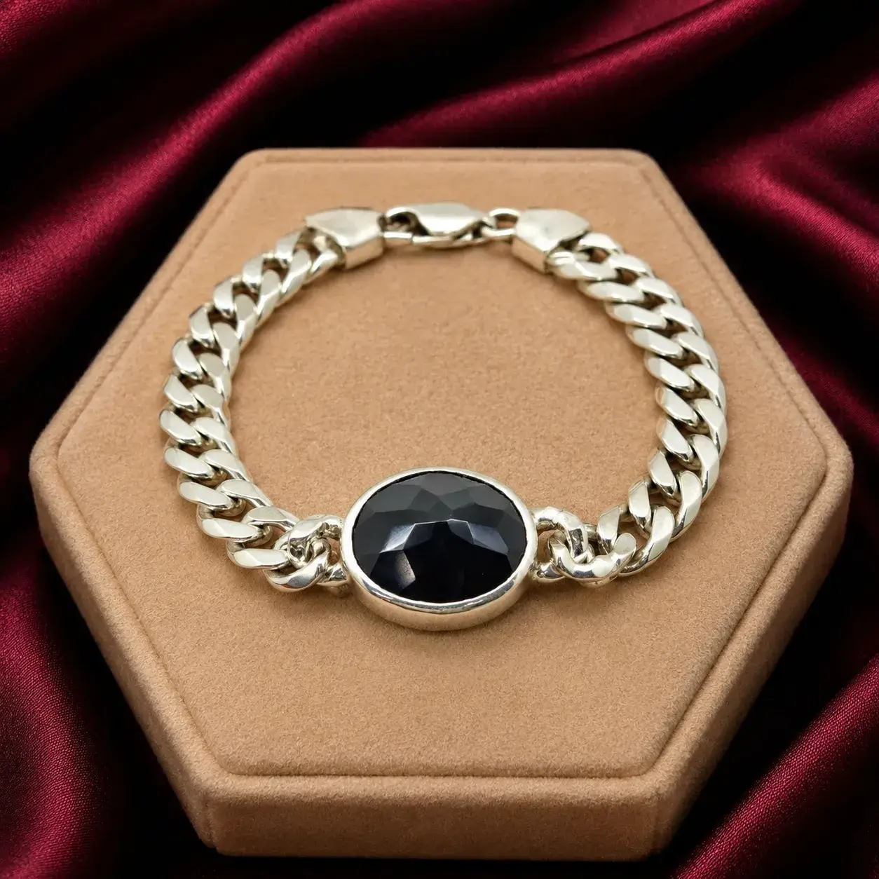 Silver chain bracelet with black onyx gemstone centerpiece on a luxury jewelry display